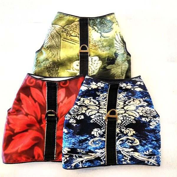 Three colorful patterned dog harness rain proof stacked on a white background